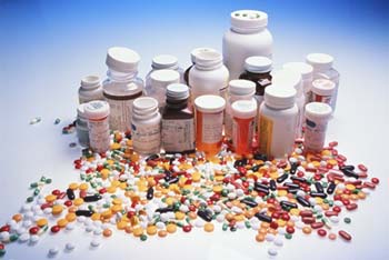 An array of open and closed supplement and drug buttles with their colourful pill contents spilled out in front of them