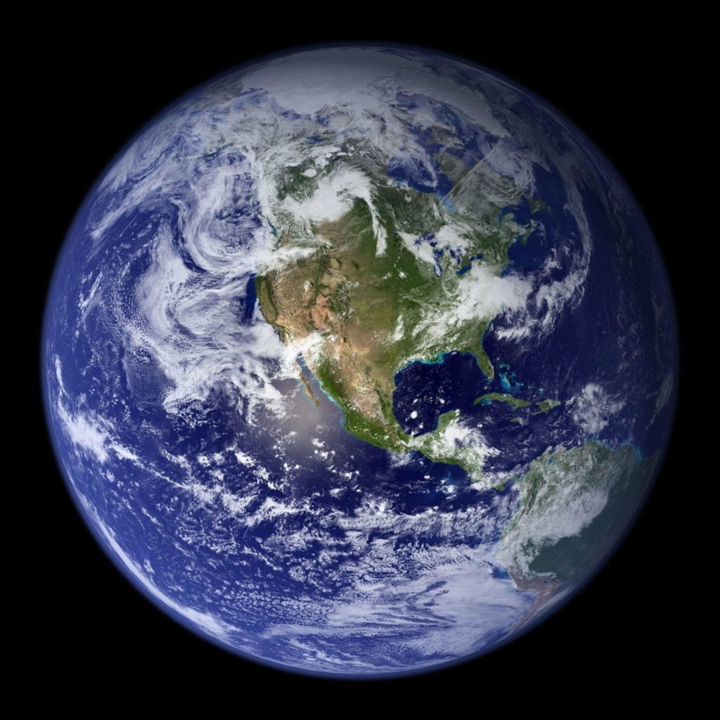 Image of planet earth on a black background, with North and Central America visible below the clouds.