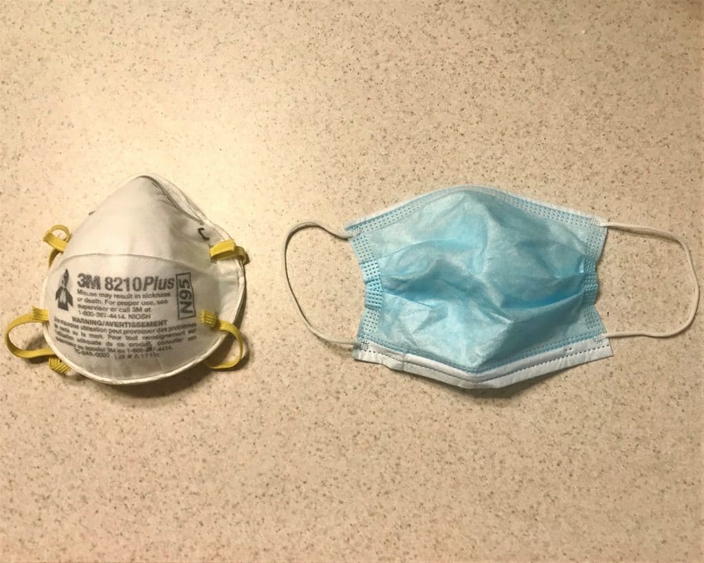 Two face masks, a white respirator and a blue surgical mask.