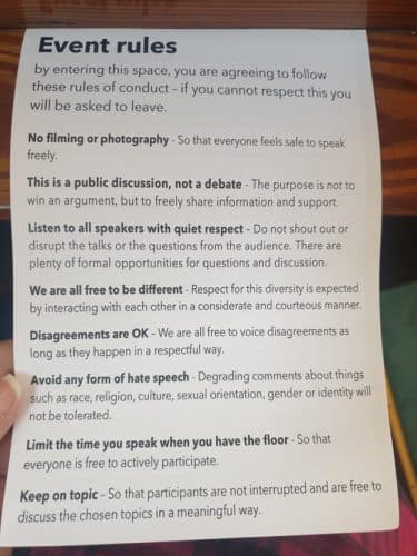 A photo of a print out of the event rules taken by the author. The event rules include "no filming or photography - so that everyone feels safe to speak freely", "this is a public discussion, not a debate - the purpose is not to win an argument, but to freely share information and support", "listen to all speakers with quiet respect - do not shout out or disrupt the talks or the questions from the audience. There are plenty of formal opportunities for questions and discussions" and so on. 