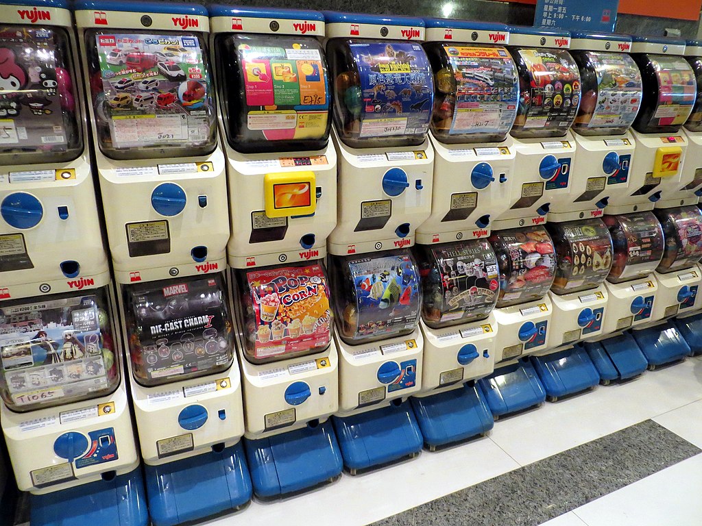 Two vertically stacked rows of 'Yujin' Gashapon machines in Hong Kong