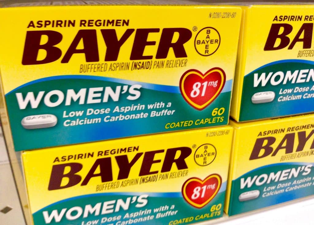 Branded aspirin boxes on a shop shelf, "Aspirin regimen, BAYER, Buffered aspirin (NSAID) pain reliever. WOMEN'S Low Dose Aspirin with a Calcium Carbonate Buffer. 81mg. 60 coated caplets"